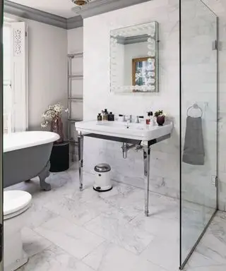 Moderne hvidt og gråt badeværelse med fritstående badekar, håndvask, toilet og bruseniche i et georgiansk rækkehus.