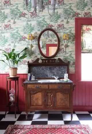 Un tocador con paneles de pared rojos y un tocador antiguo con baldosas de cuadros blancos y negros