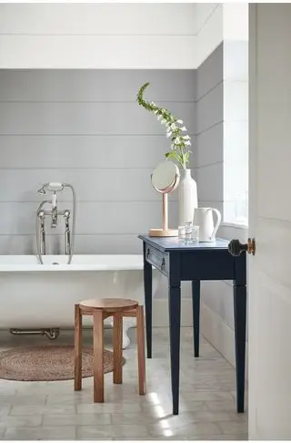 Paneles de baño grises detrás de la bañera con patas