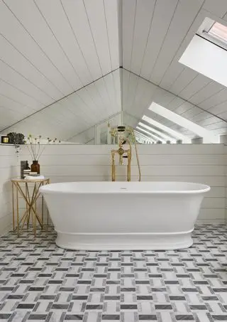 Baño blanco con suelo de mármol geométrico.