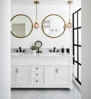 Baño blanco con tocador blanco y encimera de mármol.