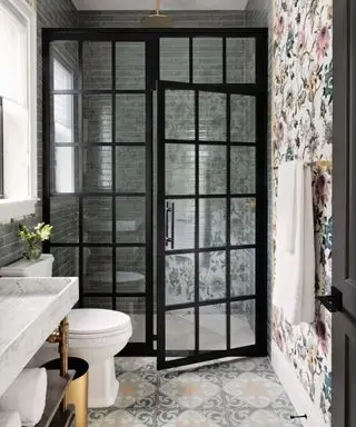 Bagno con doccia con parete piastrellata metro e carta da parati