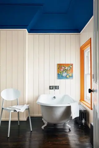 Hvidt panelbadeværelse med blåt loft