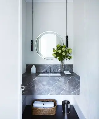 idées de salle de bains étroites, petite salle de bains avec lavabo en marbre intégré, miroir rond, paire de suspensions, panier