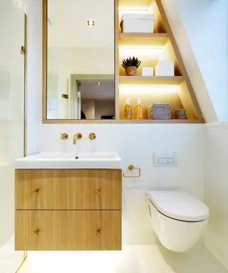 idées de salle de bains étroites, avec des murs blancs, des rangements personnalisés astucieux, des luminaires et des accessoires en laiton