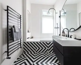 Baldosas blancas y negras colocadas al lado del baño con artículos sanitarios negros