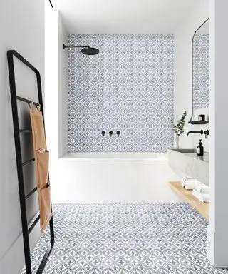 Un ejemplo de ideas de pisos para baños pequeños que muestran azulejos decorativos para pisos y paredes en azul y blanco en un baño.