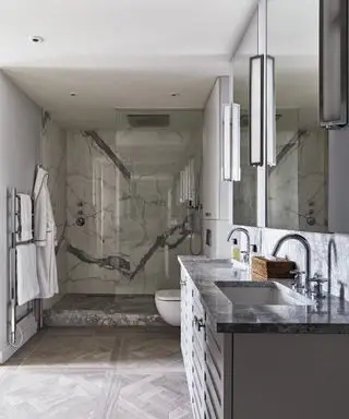 מקלחון שיש אפור גדול עם כיורים שלו ושלה