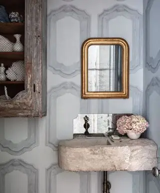 Salle d'eau avec papier peint gris Cole & Son, évier en pierre et miroir orné