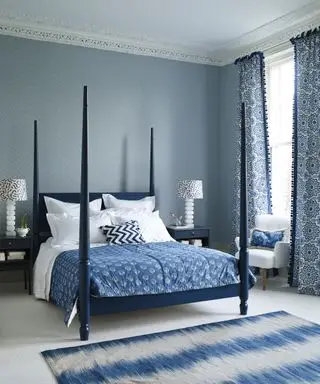 Ein Beispiel für Schlafzimmerideen für Wohnungen mit blau-weiß gemusterten Tapeten und einem dunkelblauen Himmelbett