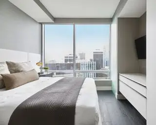 옷장 사이 벽감에 TV가 있는 침실 TV 아이디어, 도시 전망이 보이는 현대적인 아파트 침실