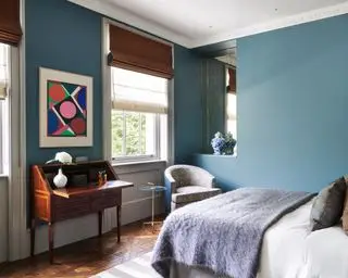 Uma ideia de quarto de adolescente com paredes azuis, arte abstrata e escrivaninha antiga