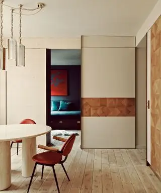 Separador de ambientes con paneles de pared y puerta corredera.