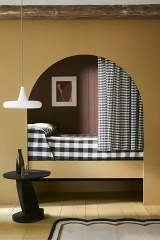 Comment agrandir une petite chambre à l'aide d'un lit en alcôve, illustré en jaune avec des planches de parquet peintes en jaune assorties.