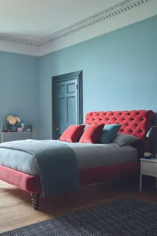 Comment agrandir une petite chambre dans un décor turquoise avec un lit rembourré en velours rose.