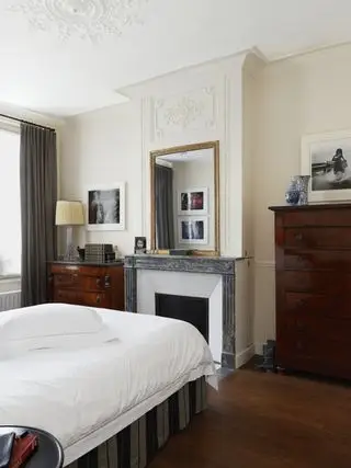 Chambre donnant sur la cheminée avec miroir au-dessus du manteau, qui montre comment agrandir une petite chambre.