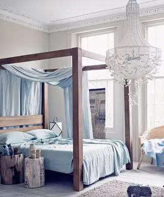 Un esempio di idee per un lampadario in camera da letto che mostra una camera da letto con un lampadario in tessuto a rete, un letto a baldacchino e biancheria da letto blu