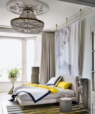 Una camera da letto con un grande lampadario in stile impero e opere d'arte contemporanea alle pareti