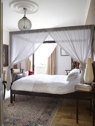 Una camera per gli ospiti con letto a baldacchino e lampadario di cristallo in una canonica vittoriana