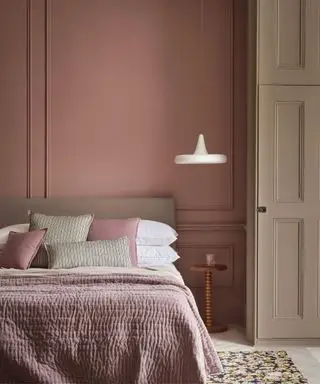 Paredes e roupas de cama rosa, luz branca pendurada