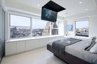 quarto estilo apartamento com TV suspensa no teto