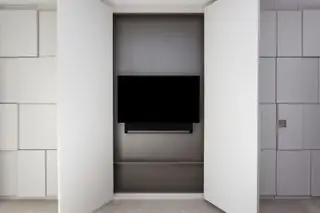 TV atrás das portas estilo guarda-roupa no quarto