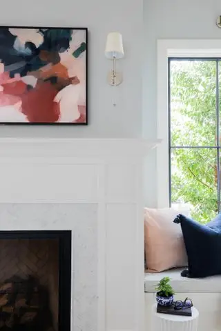 quarto ou sala de estar com TV montada acima da lareira, assento na janela