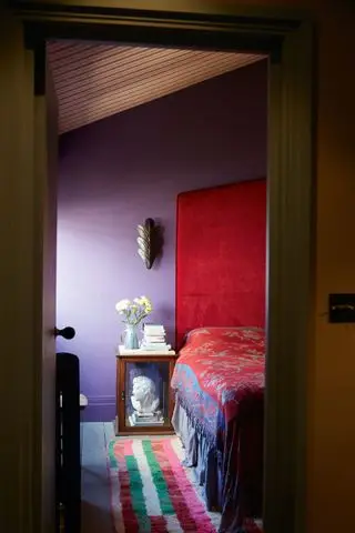 Chambre violette avec lit rouge par Rachel Chudley