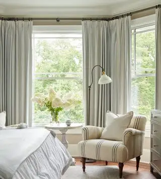 Chambre de la Nouvelle-Angleterre avec chaise recouverte de lin à rayures bleues