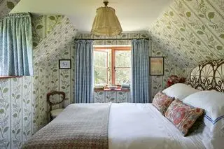 camera da letto mansardata vintage con soffitto tappezzato di Vanrenen GW Designs