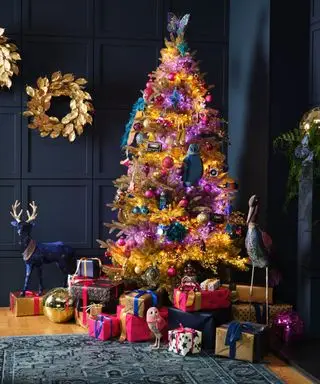árvore de Natal dourada e guirlanda, luzes roxas