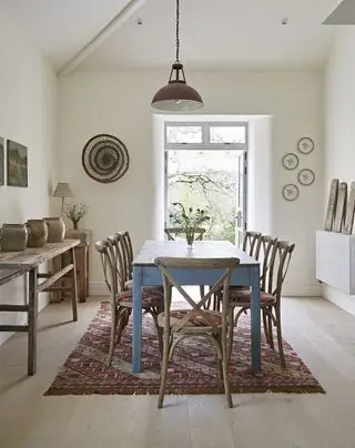 Sala de jantar neutra com mesa e cadeiras de madeira e tapete nômade estampado da Weaver Green