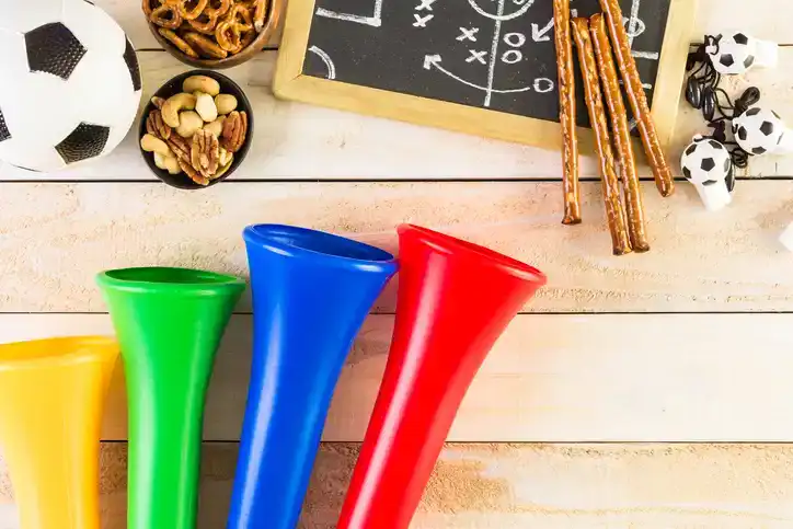 Salty snacks and vuvuzela stadium horns on the table