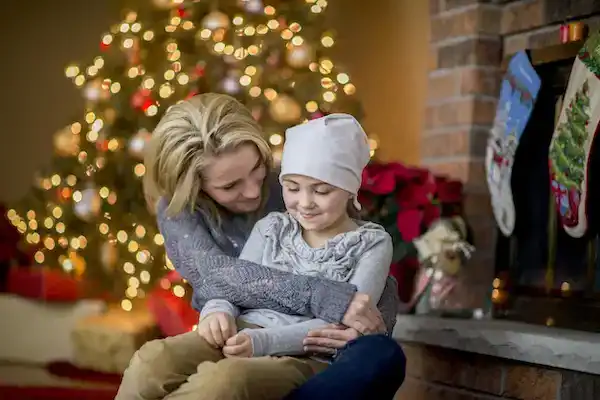 Mother choosing the right time to tell her daughter about Santa in front of the Christmas tree