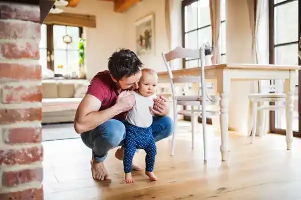 Dad helping his toddler to walk