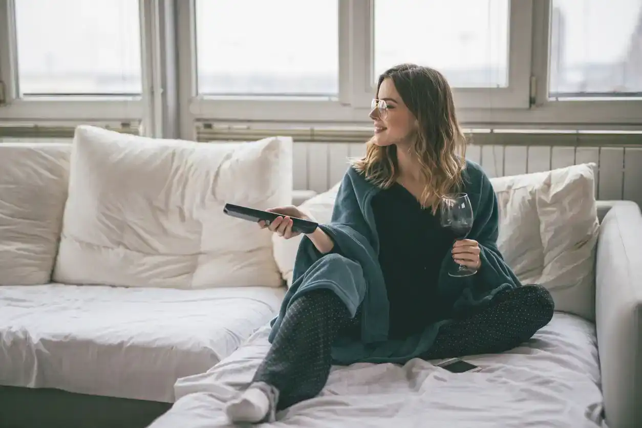 woman watching tv and drinking wine