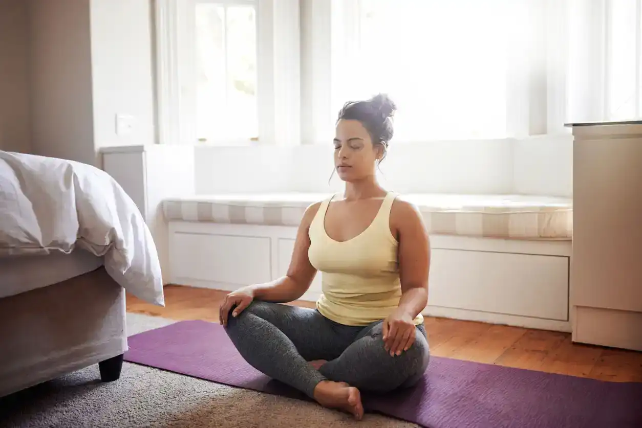 woman meditating in bedroom