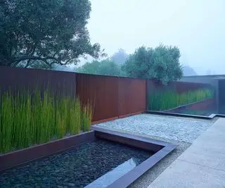 SurfaceDesign Inc가 디자인한 금속 대문이 있는 현대적인 앞마당