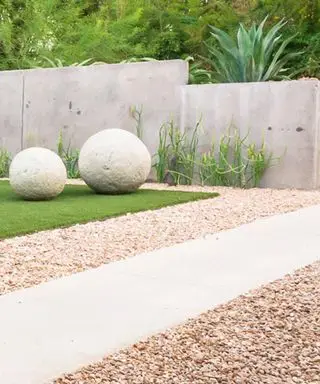 paisajismo del patio delantero con esculturas de piedra y grava