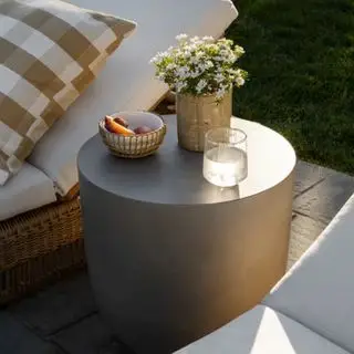 Caine Outdoor Side Table ligger mellom to solsenger
