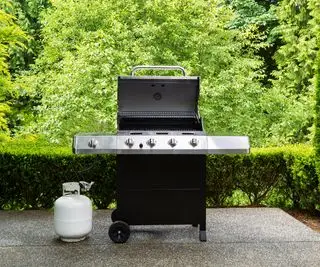 grande grill a gas e bombola di gas su un patio