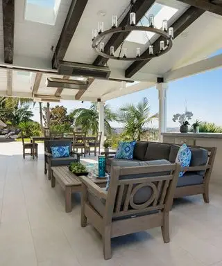 pátio de porcelanato com móveis e lustre