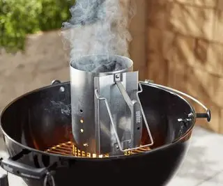 pomocí komínového startéru k zapálení grilu na dřevěné uhlí