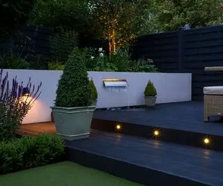 deck e degraus com iluminação, plantas e parede de água
