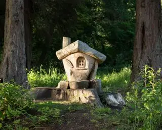 Tocón de árbol con casa de hadas de madera tallada en madera