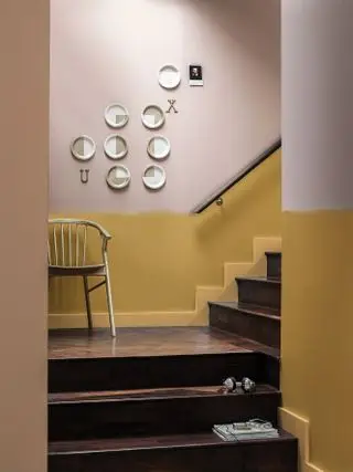 Escalera de madera con pared amarilla debajo del dado y neutral arriba