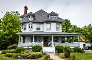 大きなポーチのあるアメリカの白いビクトリア朝の家