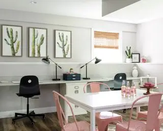 Kjeller lekseområde med hvite skrivebord og skap, hvitt bord og rosa stoler