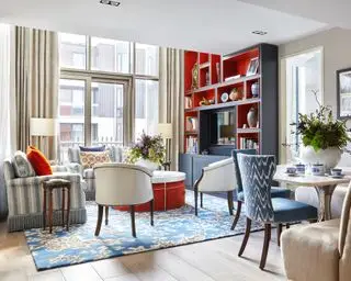 En stue med blå og oransje innredning, to sofaer og bord med spisebenk