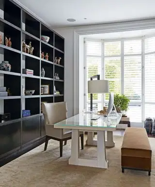 Weißes Heimbüro mit maßgeschneiderter Stauraumwand
